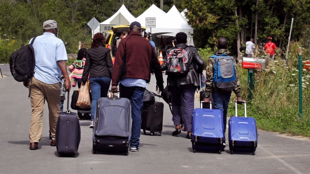 طالبو لجوء هايتيّون في طريقهم نحو الحدود الكنديّة /Charles Krupa/Associated Press