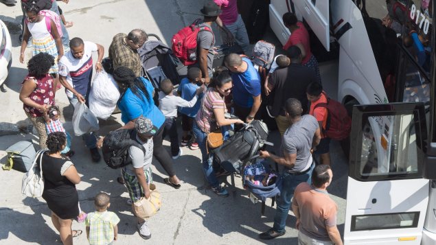 طالبو لجوء هايتيّون يصلون إلى الاستاد الاولمبي في مونتريال//Paul Chiasson/PC
