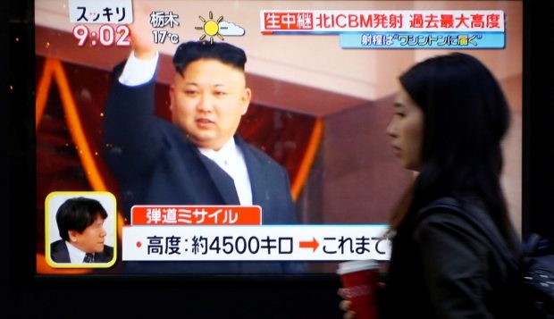 تقرير متلفز يظهر فيه زعيم كوريا الشماليّة كيم جونغ اون على شاشة مرفوعة في الشارع/Toru Hanai/Reuters