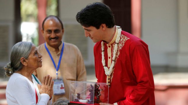 رئيس الحكومة الكنديّة جوستان ترودو يتلقّى هديّة خلال زيارته لمنزل غاندي في الهند/Reuters/Amit Dave