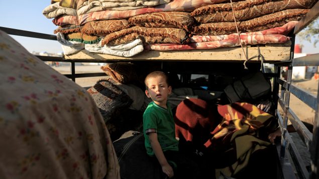 طفل من دير الزور ينزح في شاحنة تحمل مقتنيات عائلته/REUTERS/Zohra Bensemra