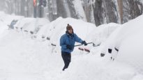A woman clears snow away from her car that was buried in snow as a late winter storm that dumped more than two feet (60 cm) of snow in Montreal