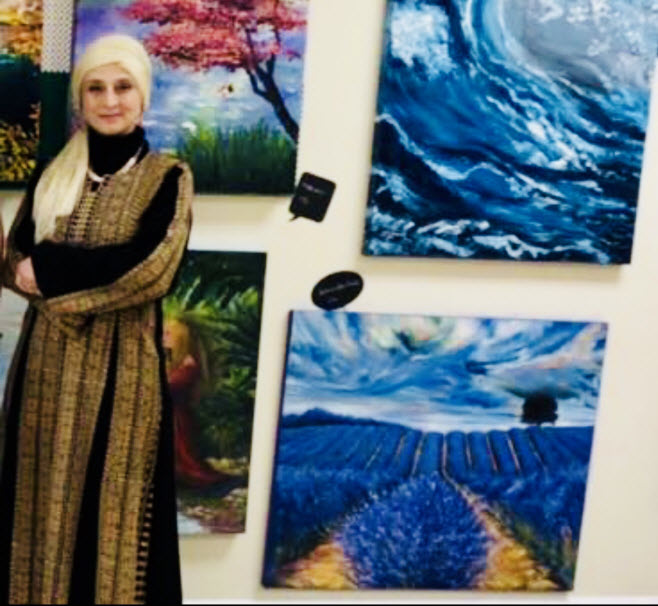 عُلا السرّاج أمام لوحاتها في آخر معرض شاركت فيه في مونتريال بدعوة منالمؤسسة الكندية-الفلسطينية/عُلا السرّاج