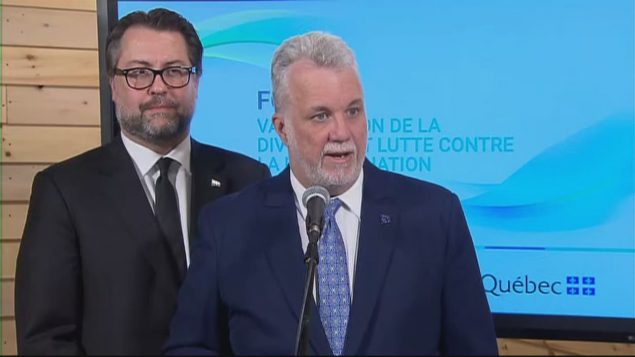 رئيس حكومة كيبك فيليب كويار بصحبة وزير الهجرة دافيد هورتيل في رد على الصحافيين/راديو كندا