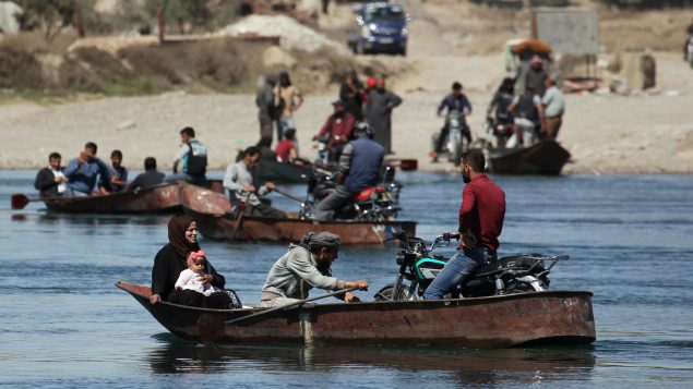 مواطنون يعبرون نهر الفرات على متن قوارب في الرقّة/.REUTERS/Aboud Hamam
