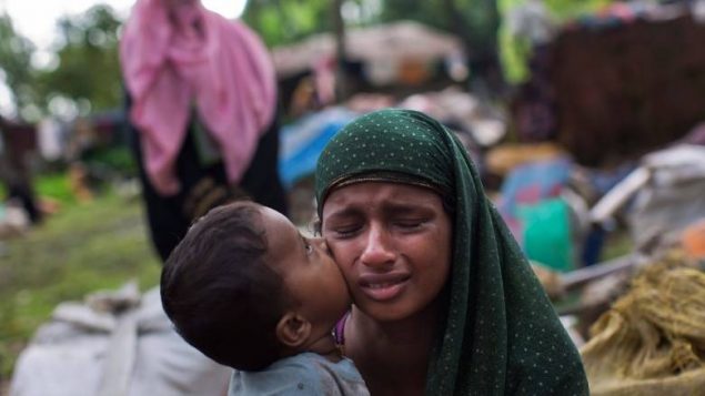 طفل نازح من اقليّة الروهينجا يقبّل والدته/Bernat Armangue/AP