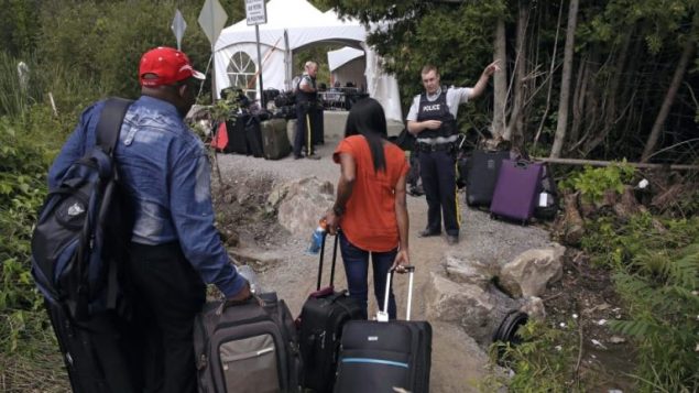 طالبو لجوء يعبرون الحدود الكنديّة بصورة غير شرعيّة/Charles Krupa/AP