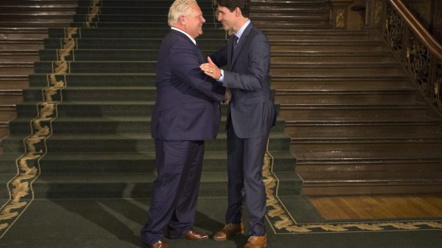 رئيس حكومة اونتاريو دوغ فورد (إلى اليسار) يستقبل رئيس الحكةومة الكنديّة جوستان ترودو لدى وصوله إلى مقرّ الجمعيّة التشريعيّة في تورونتو/Chris Young/CP