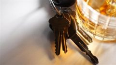 رزمة مفاتيح بجانب كأس من الخمر/iStock