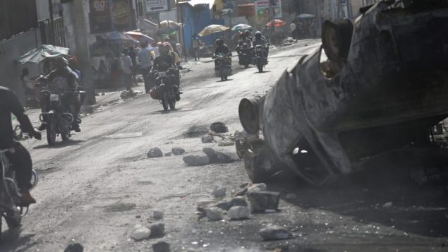 درّاجات ناريّة وسط الخراب الذي تسبّبت به أعمال العنف في بور او برانس/Reuters/Andres Martinez Casares