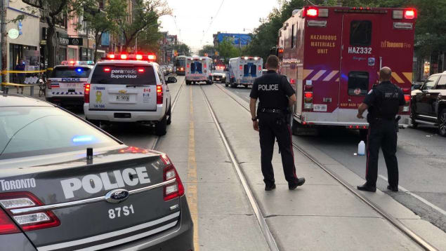 آليّات وعناصر من شرطة تورونتو وسيّارة إطفاء في شارع كوينز/: Radio-Canada/Neil Herland/CBC News