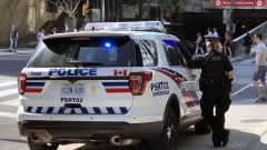 شرطيّة تقف بجانب سيّارة تابعة لشرطة تورونتو/CBC/Ian Kalushner/هيئة الاذاعة الكنديّة