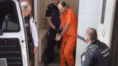 المتّهم في حادثة إطلاق النار في نيوبرنزويك ماثيو فنسنت ريموند يخرج من العربة بلباس السجناء البرتقالي وهو مكبّل اليدين /Andrew Vaughan/CP