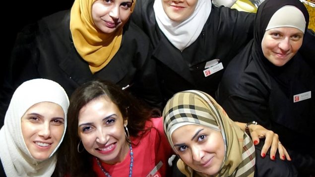 نهال علوان ( في الوسط في أسفل الصورة) مؤسّسة شركة طيّبة للمأكولات وعدد من السيّدات السوريّات اللواتي يعملن فيها/Malcolm Perry