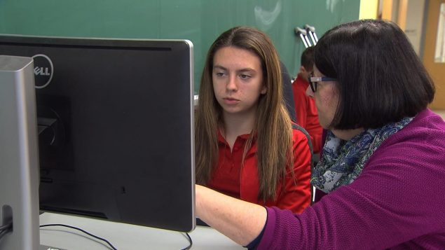 معلمة من فريق النجاح تساعد طالبة في مدرسة لوي رييل الثانوية لتجاوز صعوباتها الدراسية/راديو كندا