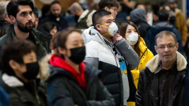 مسافرون يرتدون أقنعة للوقاية من فيروس كورونا في مطار بيرسون في تورونتو - Nathan Denette / The Canadian Press