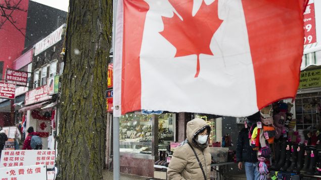 سيّدة تضع قناعا صحيّا في أحد أحياء تورونتو - 26022020 - The Canadian Press / Nathan Denette
