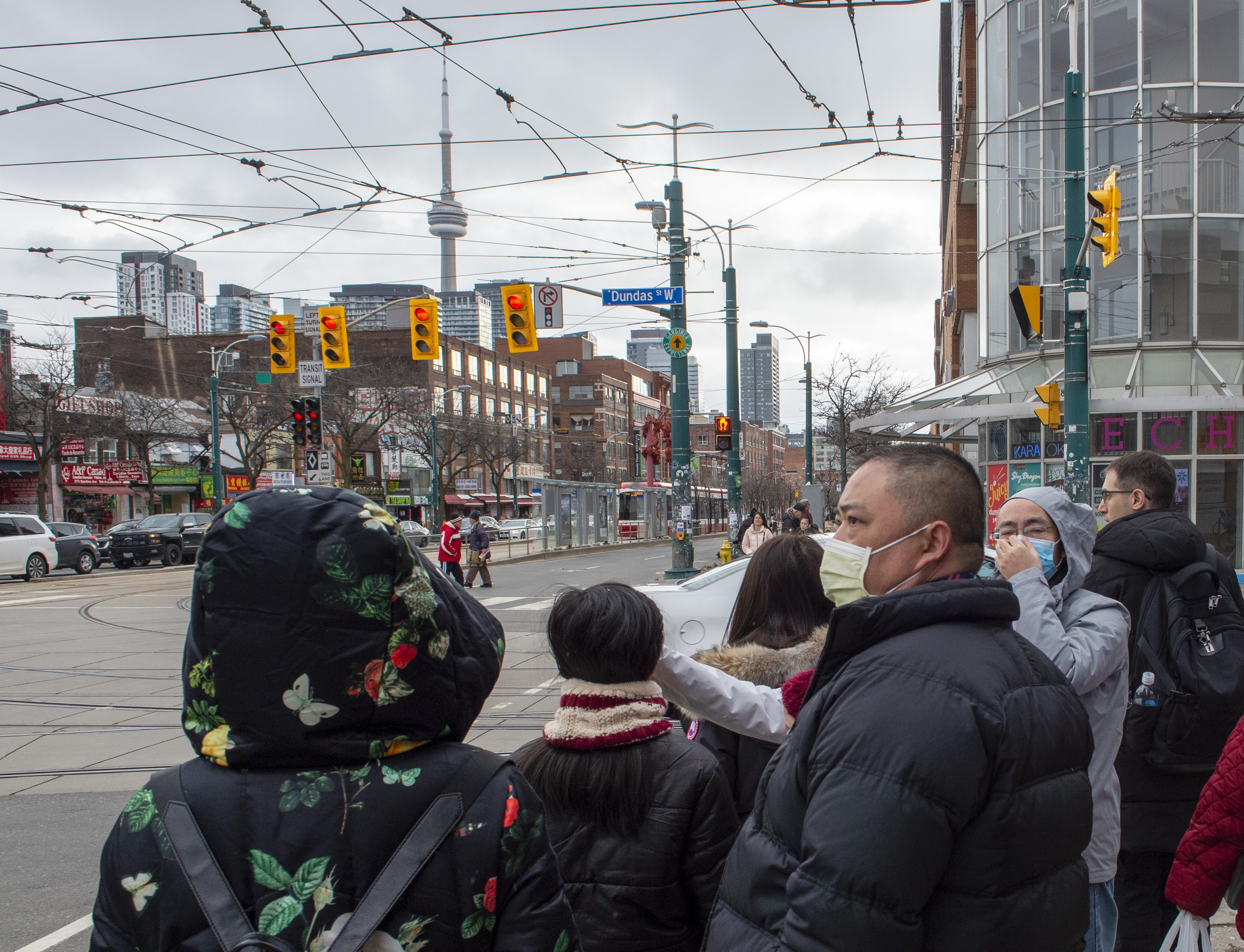 بعض المارّة في أحد شوارع تورونتو وضعوا كمّامات للوقاية من فيروس كورونا/Frank Gunn/CP