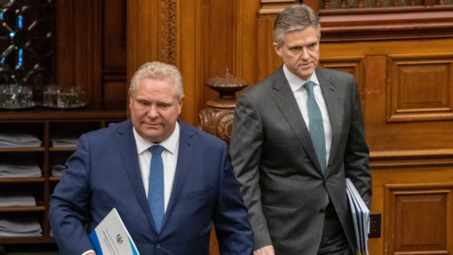 رئيس حكومة أونتاريو دوغ فورد (إلى اليسار) ووزير المال المحلّي رود فيليبس/Frank Gunn/CP