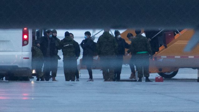 كنديّون عائدون من الصين يصلون إلى قاعدة ترينتون العسكريّة في أونتاريو في 11-02-2020/Lars Hagberg/CP