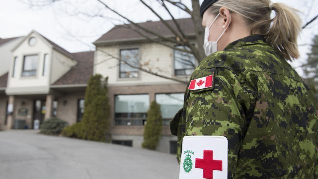 إحدى أفراد القوات المسلحة الكندية أمام مركز لرعاية المسنين في كيبيك يوم 19 أبريل نيسان 2020 - The Canadian Press / Graham Hughes