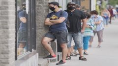 طابور لزبائن يرتدون كمامات أمام متجر في مونتريال - 27 يونيو حزيران 2020 - Graham Hughes / The Canadian Press