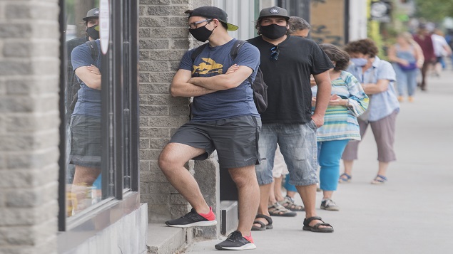 طابور لزبائن يرتدون كمامات أمام متجر في مونتريال - 27 يونيو حزيران 2020 - Graham Hughes / The Canadian Press