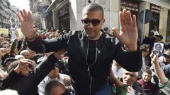 الصحفي الجزائري خالد درارني يحيّي مناصريه بعد خروجه من السجن الاحتياطي في 6 مارس آذار قبل أن يُعتقل مُجدّدا في 10 من الشهر نفسه - Photo : Ryad Kramdi / Getty Images / AFP