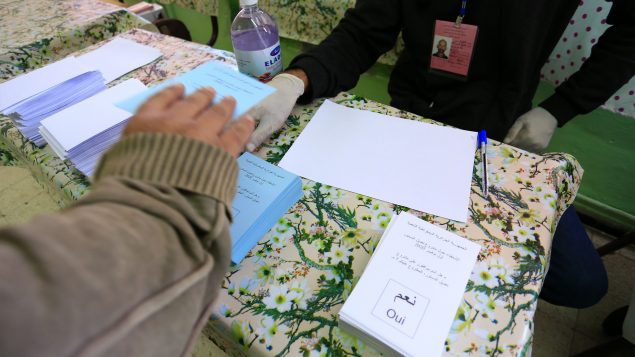 ناخب يستعدّ للتصويت في أحد مراكز الاقتراع في الجزائر العاصمة في 01-11-2020/Toufik Doudou/AP