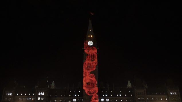 عرض بصري لزهور الخشخاش الحمراء رمز يوم الذكرى على برج السلام في البرلمان الكندي في أوتاوا في 09-11-2020//Adrian Wyld/CP