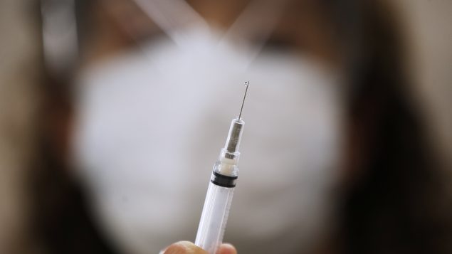 ممرّضة تُعِدّ مخفّفا لِلقاح كوفيد-19 في مركز علوم الصحّة في وينيبيغ في 16-12-2020/John Woods/CP