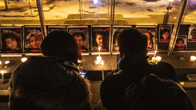 سهرة على ضوء الشموع في إدمنتون في ذكرى تحطّم الطائرة الأوكرانيّة التي تحطّمت بعد إقلاعها من مطار طهران، وظهرت صور الضحايا في خلفيّة الصورة/Jason Franson/CP