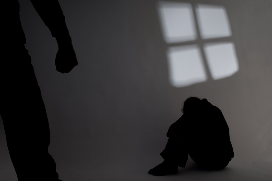Shadow of a person in the corner hiding from abuse