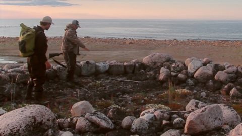 Johnny Mamgark, of Arviat, right, points out stone structures on Hubbard Point on the west coast of Hudson Bay in Manitoba just south of the Nunavut boundary.. Mamgark’s ancestors had used this site as a hunting camp about 800 years ago, with remnants of tent rigns, burial grounds, and kayak rests. It was and ideal site to spot Beluga and seals,, and on land to spot caribou or bears. © Canadian Press