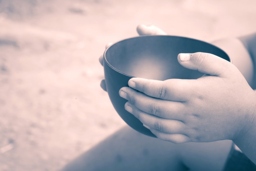 vintage color of a hungry children holding an empty bowl
