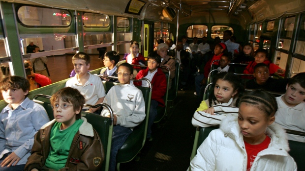 Students sit next to each other on the actual bus where Rosa Parks, a black woman, refused to give up her seat to a white man 50 years ago in Alabama, during their school visit to Henry Ford Museum in Dearborn, Michigan. (Rebecca Cook/Reuters)