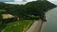 Aerial view of the Fundy shore with the FORCE visitor centre in clearing at left. A power substation is about 1km away with buried cables under the land are laid across the bay seafloor to the generators out in the current (CLICK to ENLARGE)
