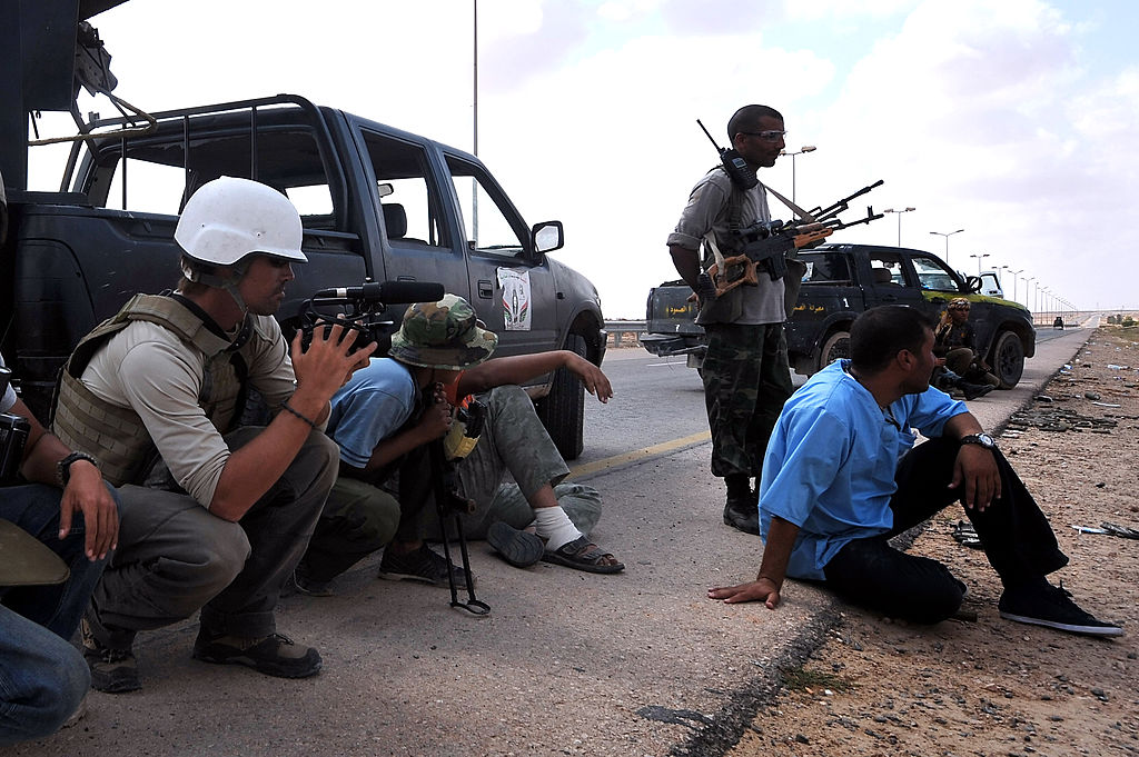 A photo taken on September 29, 2011 shows US freelance reporter James Foley (L) on the highway between the airport and the West Gate of Sirte, Libya. Foley was kidnapped and executed by ISIS in 2013. ARIS MESSINIS/AFP/Getty Images)