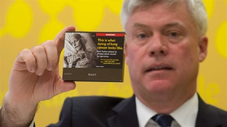Rob Cunningham holds a package of cigarettes with a proposed plain packaging design..