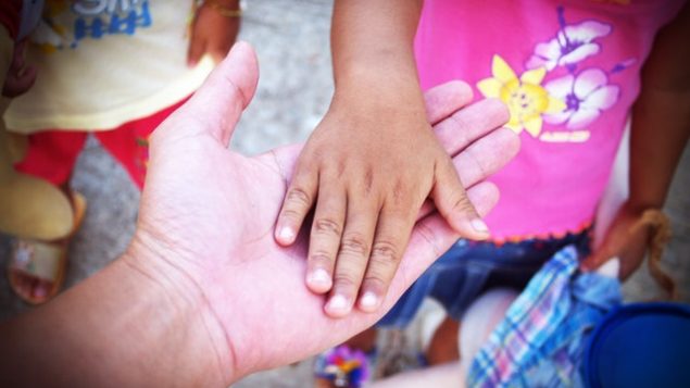 Child hand in parent's hand