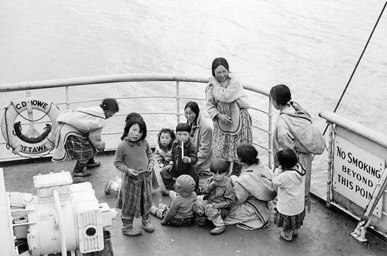 Indigenous people await medical examination aboard the Coast Guard Ship C.D. Howe at Coral Harbour, N.W.T. (now Coral Harbour/Salliq, Nunavut) in July, 1951. Throughout the 1950s and 60s, the Canadian Coast Guard ship made summer medical trips to the Eastern Arctic. If an infectious disease such as tuberculosis was found during the medicals, the infected individual was kept on board and not allowed to go ashore to collect belongings or say goodbye, before sailing south for treatment, which could take several years (National Film Board- Library and Archives Canada)