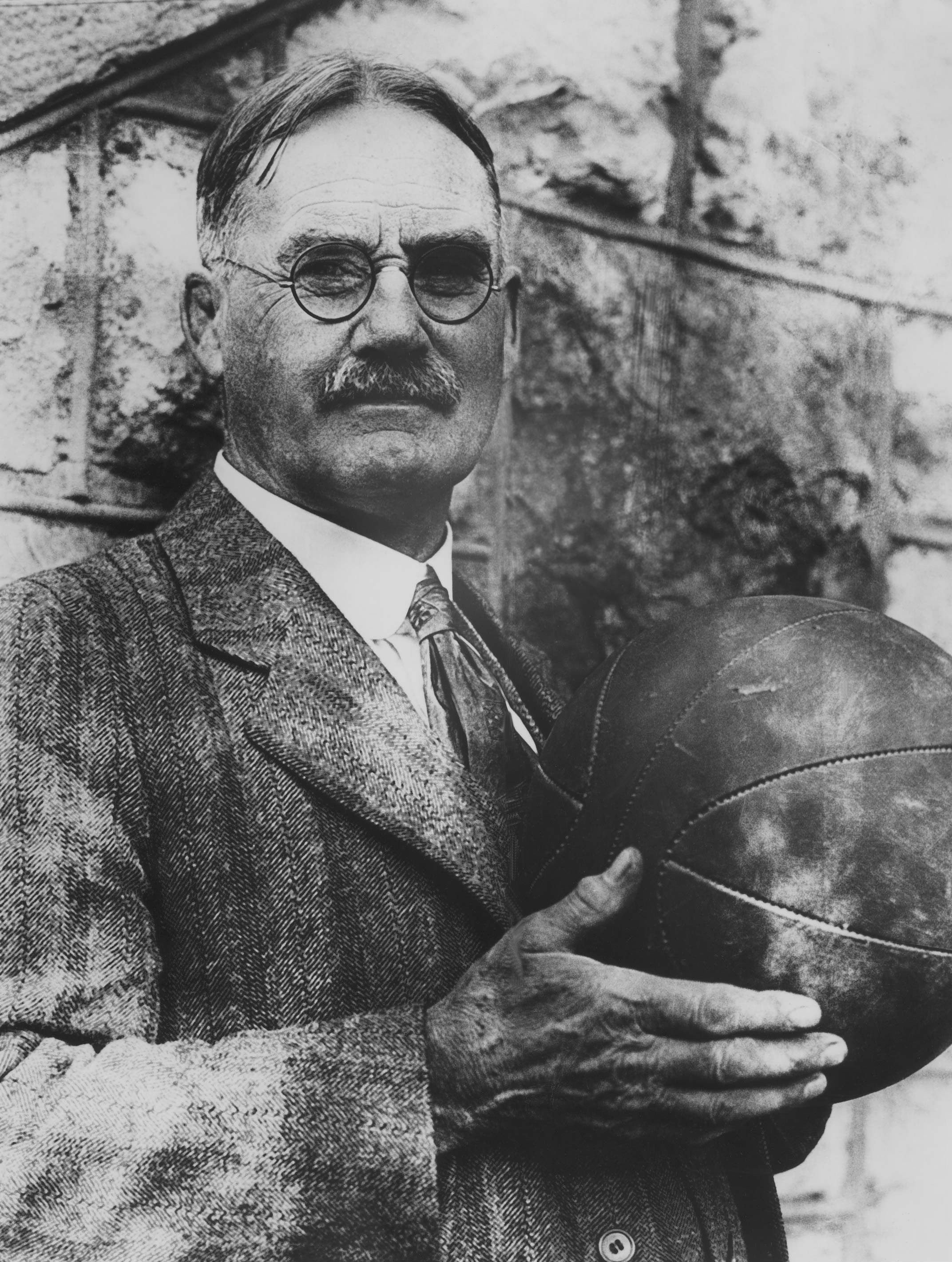 Dr. James Naismith is known as the "Father of Basketball" for he invented the game in 1891, at the Springfield, Mass. Y.M.C.A. College. At present , the doctor is professor of physical education at the University of Kansas, where he still shoots enough baskets to keep in good physical trim, as photo will testify. (AP PHOTO) December 13, 1929