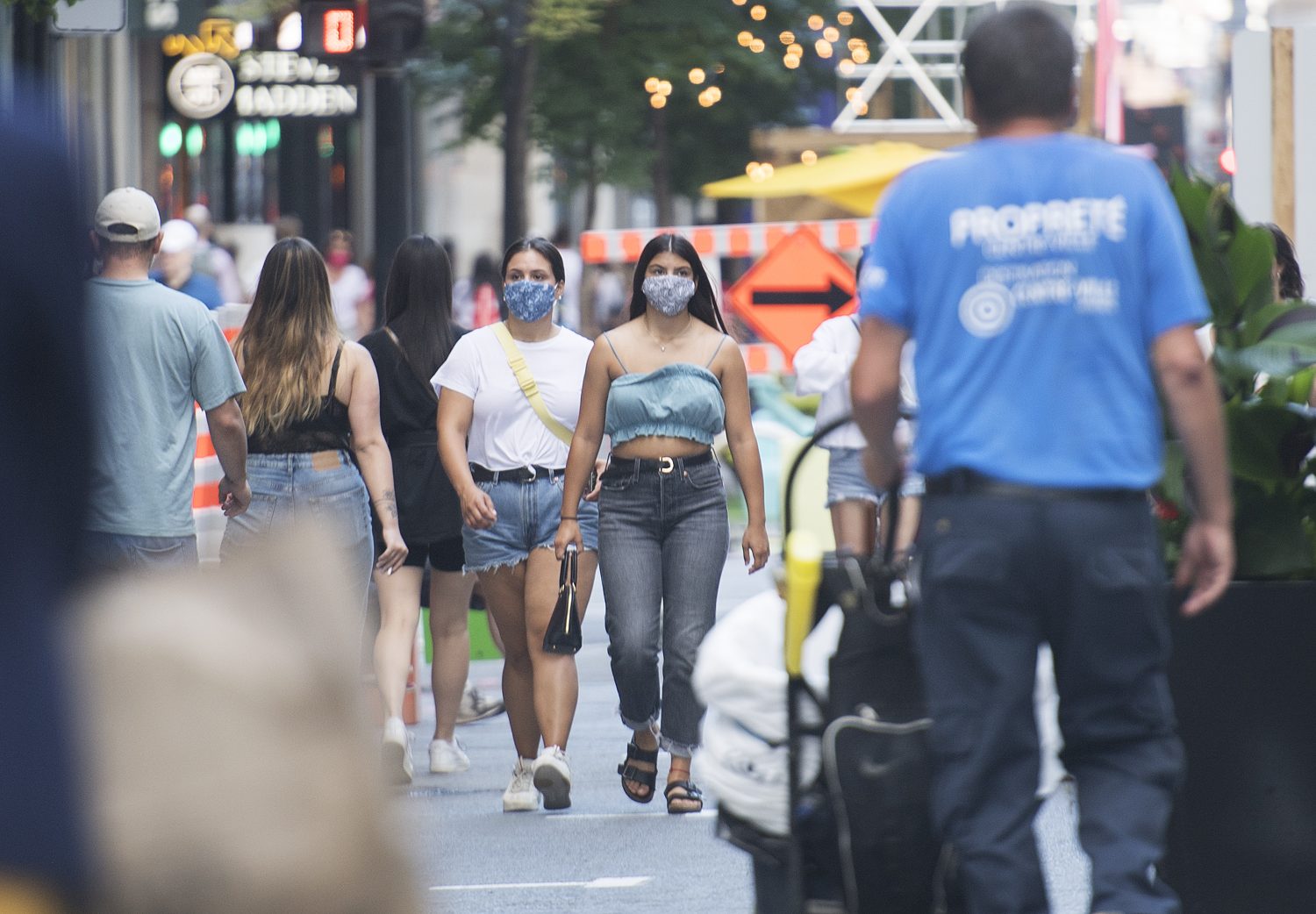 People wear face masks as they walk along a street in Montreal – RCI