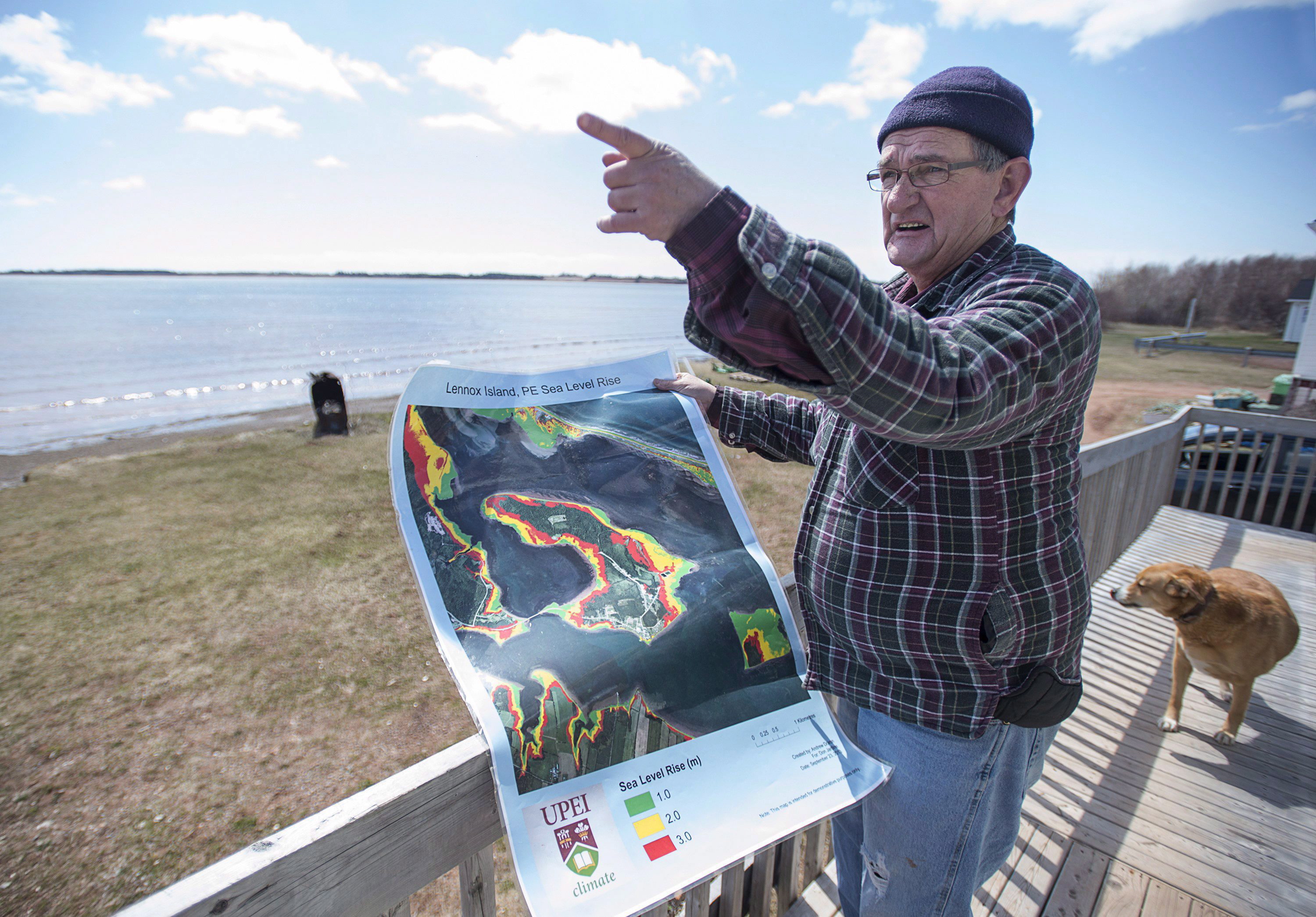 El residente de Lennox Island, Dave Haley, muestra un mapa del laboratorio de investigación climática de la Universidad de la Isla del Príncipe Eduardo, que muestra el aumento del nivel del mar en la isla. ©The Canadian Press/Andrew Vaughan