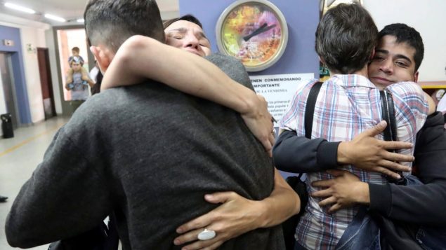 cuatro personas se abrazan despues del fallo que condenó a dos curas a mas de 40 años de prision por abuso sexual de menores sordos.