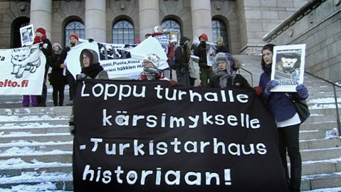 Protestors on the steps of Parliament in Helsinki. The banner reads, 