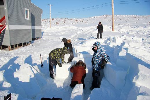 Making an igloo outside of Ulukhaktok's school. Usually the igloo is made out on the frozen harbour, but this year, the snow was not the right consistancy. Photo: Eilís Quinn, Radio Canada International. 