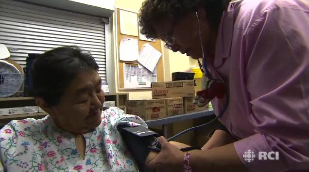 Minnie Akparook checking a patient's blood pressure. Screen shot from: Caring for our People: Inside Arctic Nursing documentary.