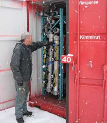 Mark Jones, a coast guard environmetnal response officer, check the contents of an Arctic community spill preparedness kit bound for Kimmirut, another community in Nunavut's Baffin Island region. (Canadian Coast Guard)