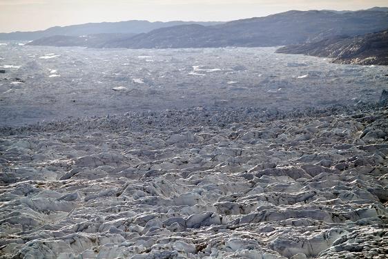 In this July 19, 2011 file photo, rows of pressure ridges stack up, foreground, before tumbling over the ever-collapsing wide front of Jakobshavn Glacier and into the Ilulissat ice fjord, background, in Greenland. (AP Photo/Brennan Linsley, File) 
